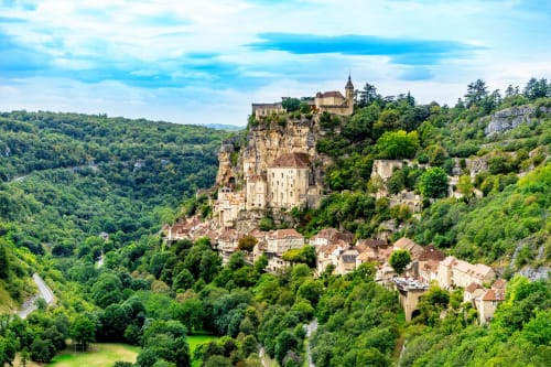 Château médiéval perché sur une falaise rocheuse entouré de forêts verdoyantes à Châlus, France