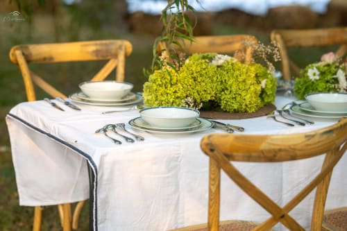 Elegant outdoor dining setup at Domaine De Bafave with place settings, green floral centerpiece, and wooden chairs