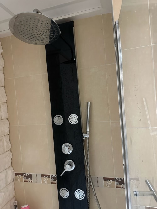Panel de ducha moderno negro con alcachofa de lluvia y jets corporales en el baño de un apartamento en Home Guardian Services, Sant Jordi