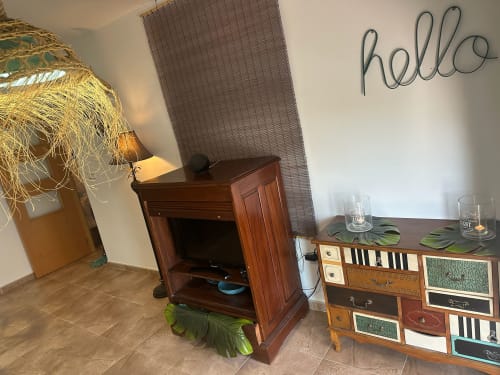 Acogedor salón del apartamento Sant Jordi con muebles de madera, iluminación decorativa, letrero de neón hello y comodidades modernas