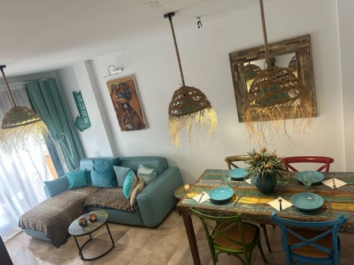 Acogedor apartamento Sant Jordi con asientos turquesa, mesa rústica, lámparas colgantes tejidas y vistas a las montañas