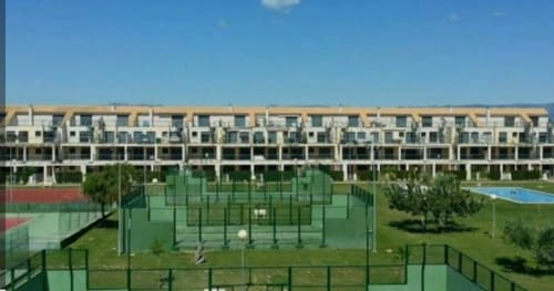 Complejo residencial moderno en Sant Jordi con pistas de tenis, piscina y áreas verdes bajo un cielo azul despejado