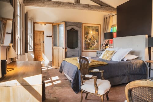 Spacieuse chambre aux Les Jardins de Baracane avec poutres rustiques, mobilier vintage et lumière naturelle à Avignon