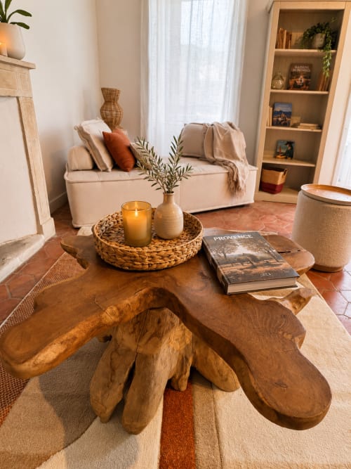 Salon cosy du B&B Entre Ciel et Lettres avec table basse sculptée en bois, canapé crème et décoration tissée