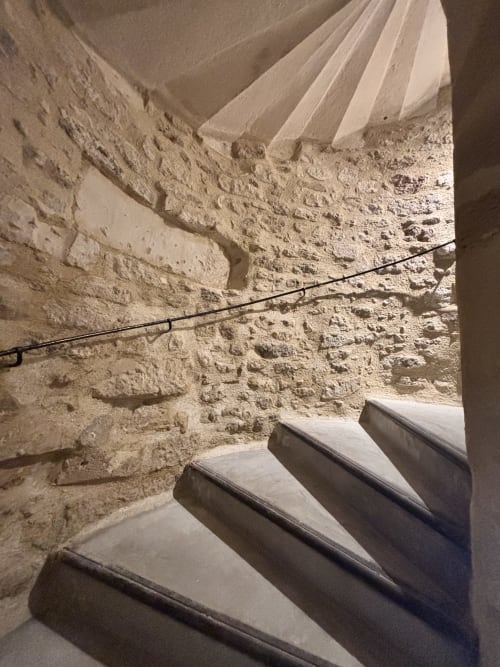 Escalier en spirale aux murs de pierre à Entre Ciel et Lettres, gîte rustique français