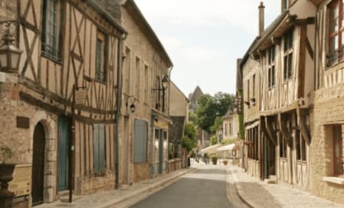 Rue médiévale pavée à Montmirail avec maisons à colombages, architecture villageoise française pittoresque pour Demeure De La