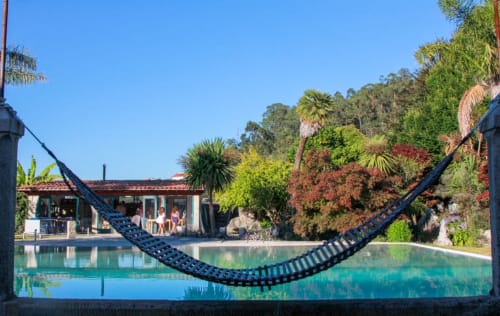 Rede preta com vista para piscina tranquila na Quinta da Malaposta Boutique Hotel em Vila Nova de Cerveira, Portugal