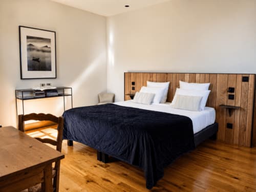 Chambre moderne à la Domaine De Cazal B&B à Saint-Cyprien avec lit en bois, literie blanche et parquet