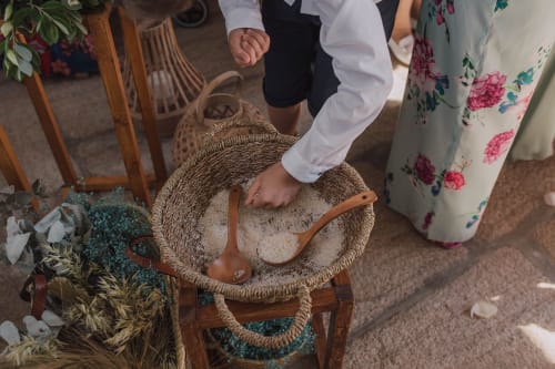 Mão de bebê tocando cesto trançado na celebração de casamento da Quinta da Malaposta com flores secas e decoração floral
