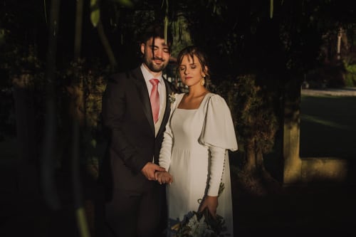 Noivos de mãos dadas na Quinta da Malaposta Boutique Hotel em Vila Nova de Cerveira, Portugal ao anoitecer