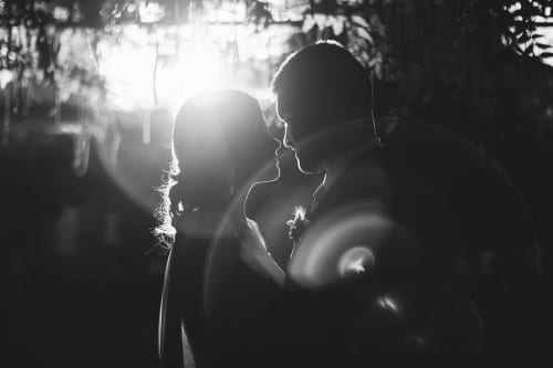 Noivos silhuetados contra luzes da noite na celebração de casamento da Quinta da Malaposta