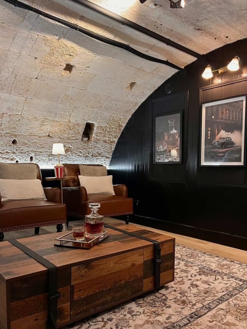 Stylish lounge in L'Arcade Secrète apartment, Bordeaux, with leather seating, wooden coffee table, and exposed stone ceiling