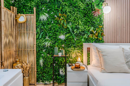 Modern bedroom at Wellkhome Bordeaux with living green wall, bed with white pillows, and ambient lighting