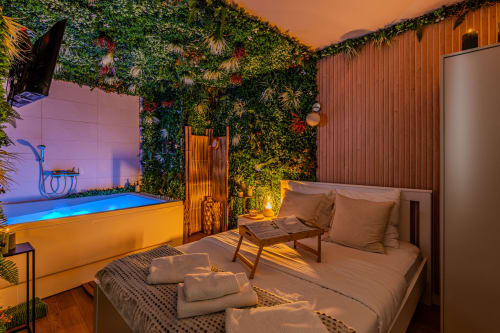 Chambre luxueuse avec mur végétal, piscine chauffée et éclairage ambiant à Wellkhome Bordeaux