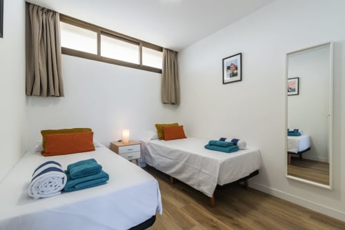Bright twin bedroom in Cactus Dunes Seaview apartment, Gran Canaria, with blue towels and sea views