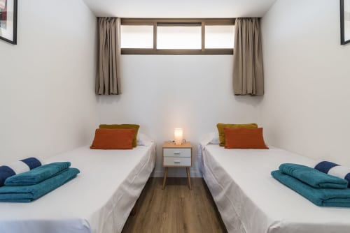 Twin beds with teal linens in a bright bedroom at Cactus Dunes Seaview apartment, Gran Canaria