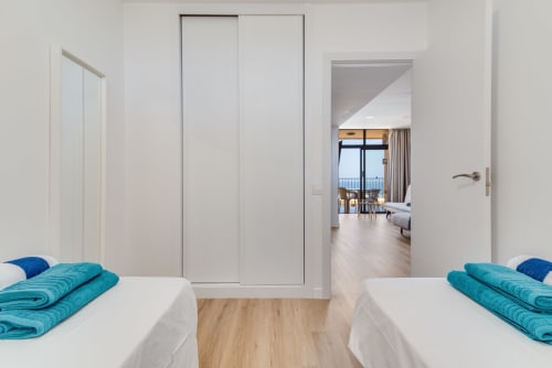 Twin beds with turquoise towels in bright bedroom at Home Stay Gran Canaria, sea view apartment in Gran Canaria
