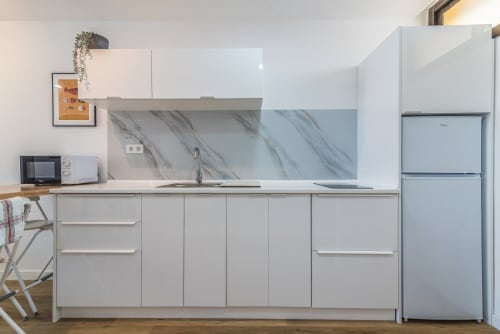 Modern kitchen in Cactus Dunes Seaview apartment at Home Stay Gran Canaria with white cabinetry, marble backsplash, and