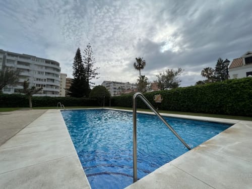 Piscina de la propiedad Grupo Inmohouse en Fuengirola con áreas de descanso y arquitectura mediterránea