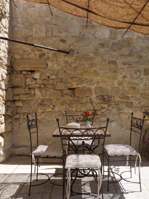 Terrasse ombragée du Mas Petit Prince à Arles - table et chaises en fer forgé avec fleurs rouges