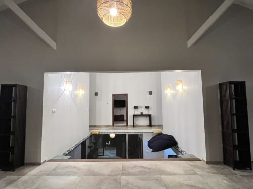 Salon encastré moderne aux murs blancs, mobilier noir et éclairage ambiant au gîte Les Hébergements Passion
