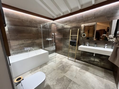 Salle de bains moderne du gîte Les Trois-Ilets avec douche vitrée, baignoire blanche, double vasque et plafond chauffant illuminé
