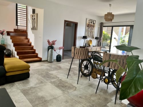 Salon cottage moderne aux Hébergements Passion en Martinique, avec escalier bois, mobilier jaune, décoration vélo