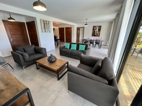 Séjour moderne avec canapés gris, table basse en bois et touches turquoise au gîte Les Hébergements Passion