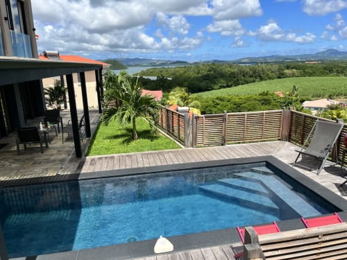 Piscine privée et terrasse des Hébergements Passion en Martinique avec vues sur la mer et les montagnes