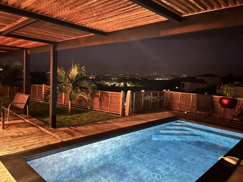 Piscine privée illuminée du gîte Les Hébergements Passion avec terrasse vue mer sur Les Trois-Ilets, Martinique