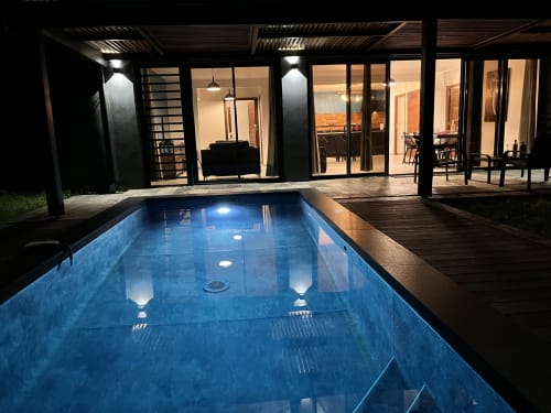 Piscine privée chauffée la nuit avec terrasse illuminée, transats et cottage moderne aux Hébergements Passion