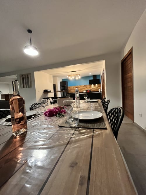 Salle à manger moderne de la maison d'hôtes Passion Vanille Cannelle aux Hébergements Passion, Martinique, avec table en bois noir