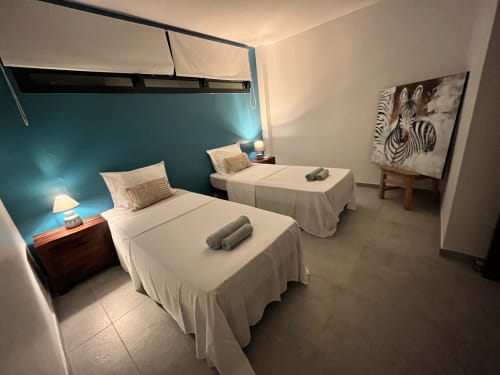 Chambre twin avec mur d'accent vue mer aux Hébergements Passion, cottage martiniquais aux équipements modernes