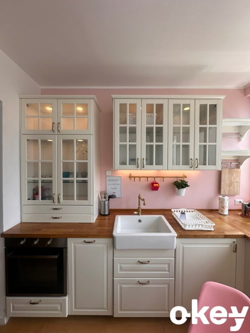 Moderna cucina rosa con mobili bianchi, lavello in stile rustico e piano cottura in legno nell'appartamento di Bari