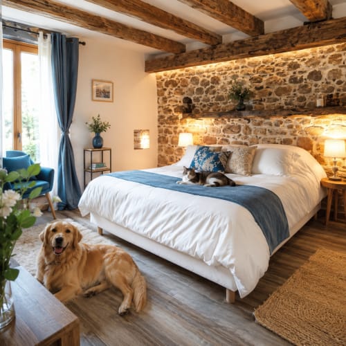 Chambre rustique à La Synchronicité B&B avec murs en pierre, poutres en bois, deux chiens sur le lit et le sol