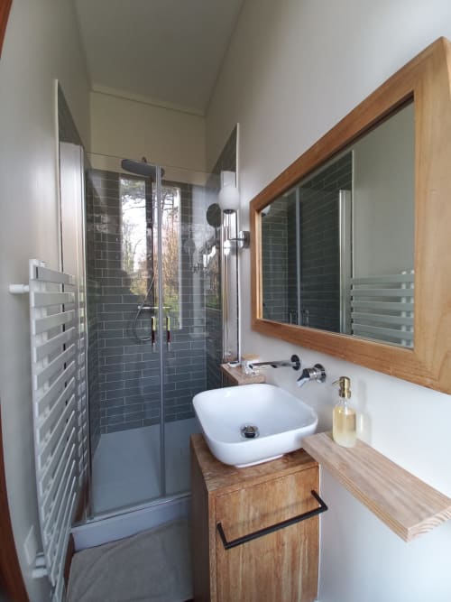 Modern bathroom with walk-in shower, white vessel sink, wooden vanity, and garden view mirror at Villa Eliane, Étretat