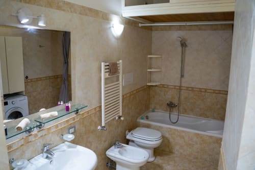 Modern bathroom at Sorrento Sea View with bathtub, toilet, bidet, heated towel rack, and vanity sink with mirror