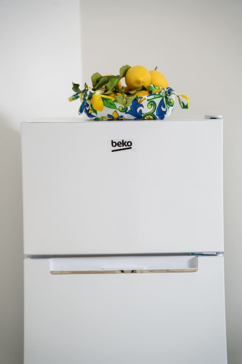 White Beko minibar with fresh lemons in decorative bowl at Sorrento Sea View hotel apartment