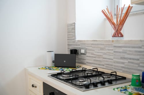 Modern kitchenette in The Cave On The Sea apartment at Sorrento Sea View with gas cooktop and grey tile backsplash