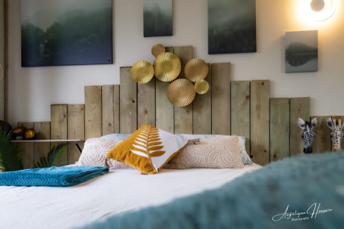 Chambre moderne aux Rives du bel air avec tête de lit en bois, décor doré et œuvres d'art thème safari