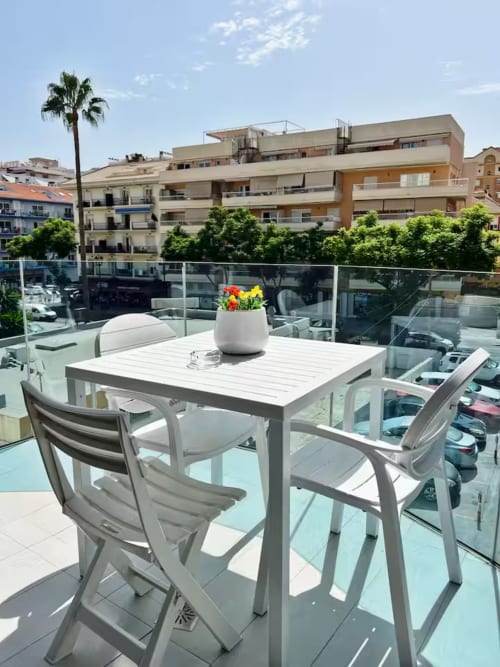 Elegante terraza con comedor con vistas a apartamentos de Fuengirola y palmeras, comodidades de apartamento de lujo