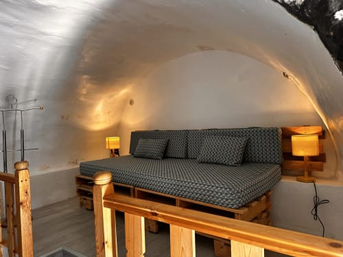 Lit à cadre bois avec literie grise à motifs dans cottage blanc aux voûtes élancées de Le Rupicapra, retraite en montagne Roubion