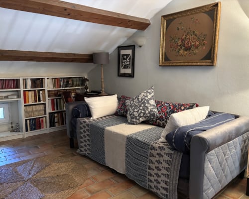 Suite Fleur au Domaine Du Commandeur, Mondragon - coin salon douillet avec canapé gris, poutres apparentes, bibliothèques et tableaux