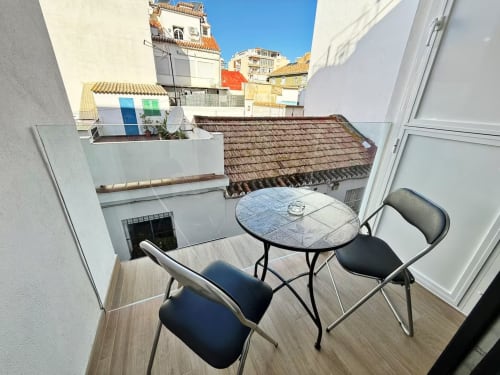 Balcón de apartamento frente al mar en Fuengirola con asientos y vistas de edificios blancos históricos