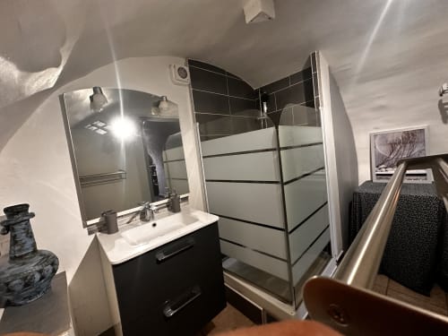 Salle de bain moderne au gîte Le Rupicapra à Roubion : vanité noire, grand miroir et douche à l'italienne