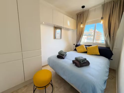 Apartamento de playa moderno y soleado en Fuengirola con cama doble, detalles amarillos, vistas a la ciudad y decoración contemporánea