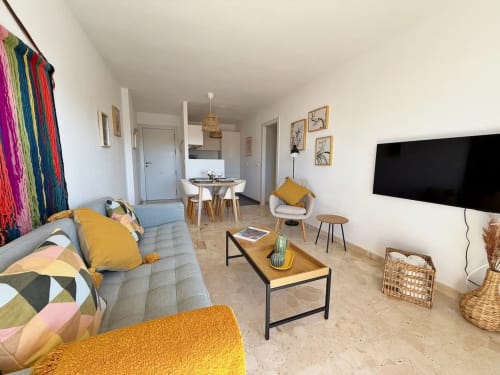 Apartamento moderno frente al mar en Fuengirola con vistas a la ciudad, mobiliario contemporáneo y decoración colorida