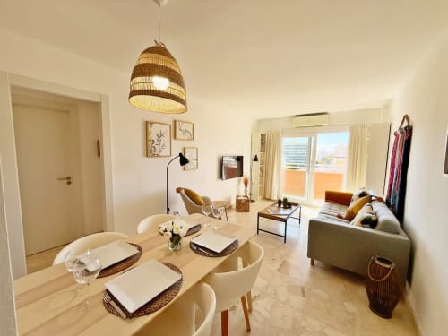 Moderno apartamento en playa soleada de Fuengirola con salón-comedor abierto, vistas a terraza y mobiliario contemporáneo