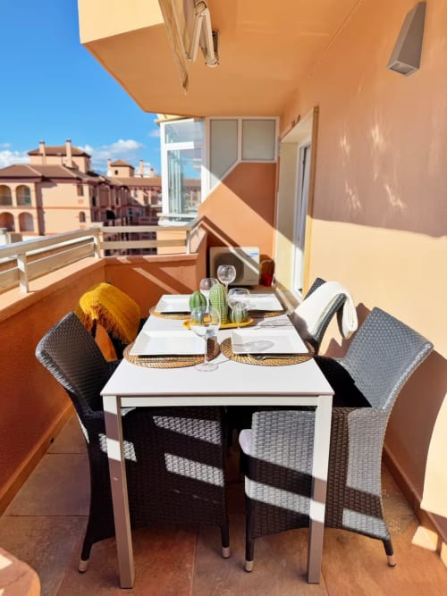 Moderna terraza soleada en Fuengirola con mesa de comedor, cactus decorativo y vistas a la costa mediterránea