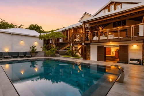 Villa de luxe aux Balcons d'Oyster Pond, Saint-Martin, avec piscine illuminée, terrasse en bois et cuisine gastronomique au crépuscule